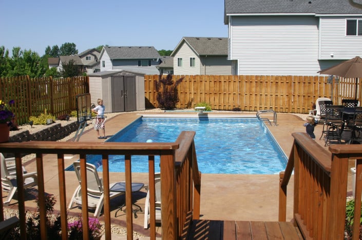 backyard pool with deck and boy.