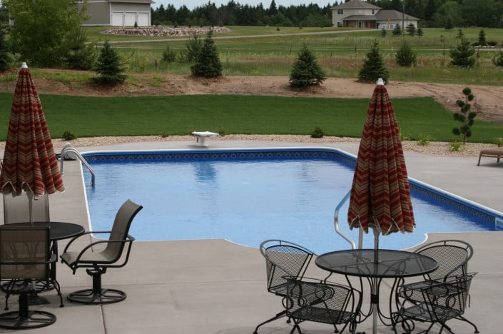 backyard pool with two seating areas.
