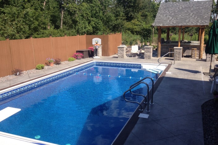 backyard pool with diving board and gazebo.