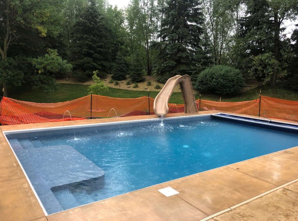 new pool construction with sun deck and slide.