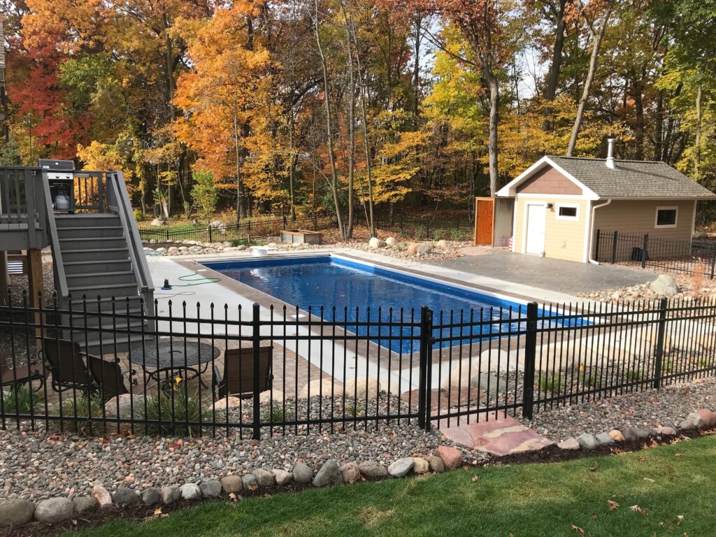 backyard pool with fence and pool house.