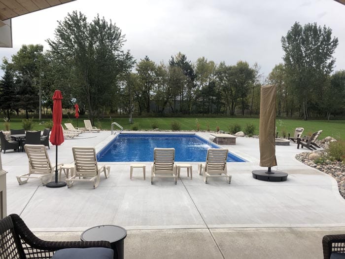 backyard pool with lounge chairs.
