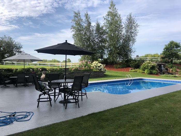 backyard pool with seating area.