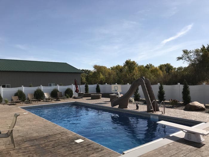 backyard pool with fence and slide.