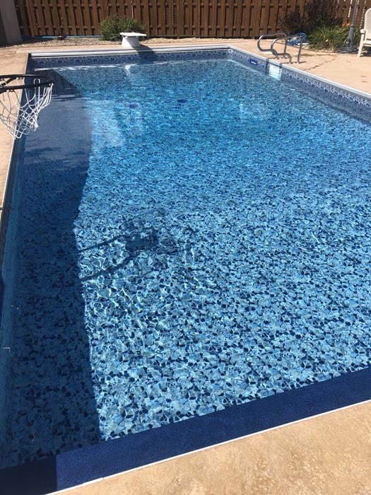 backyard pool with diving board and basketball.